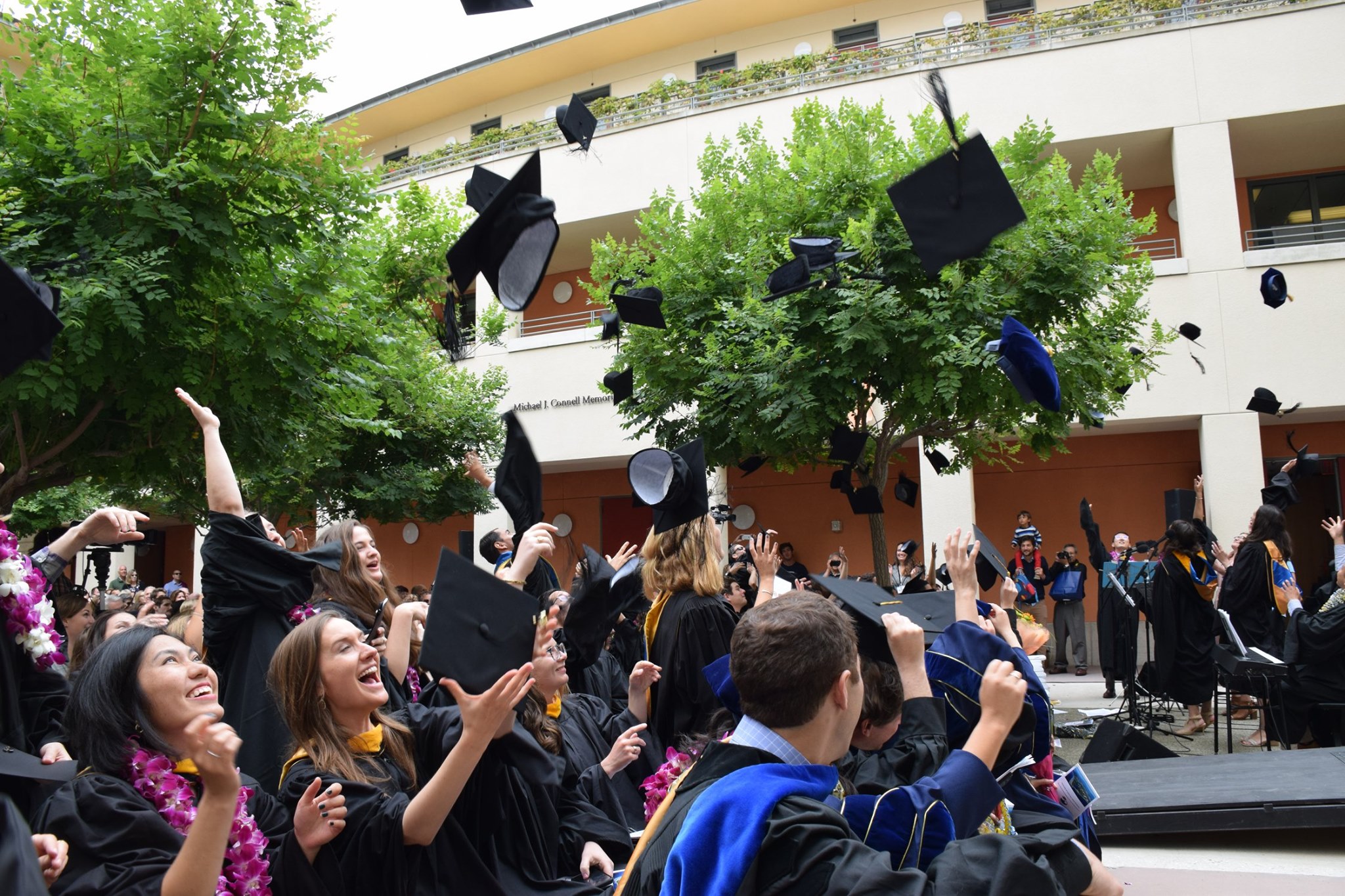 Graduates throwing mortar board caps into the air 