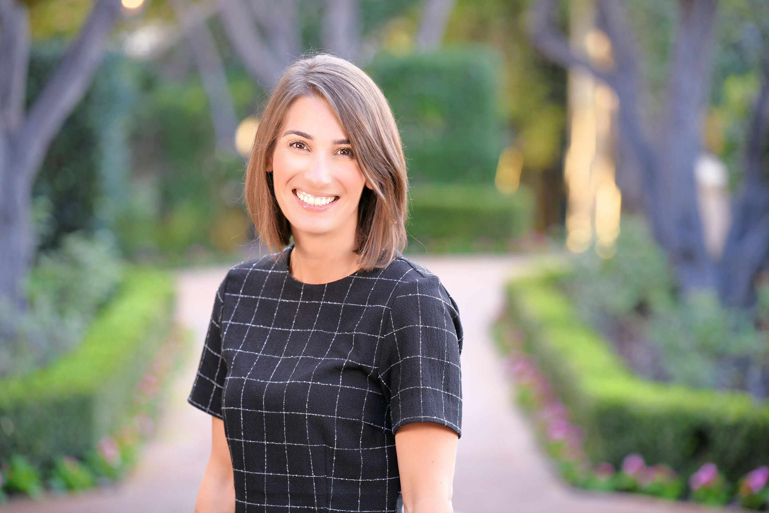 Smiling woman stands on a brick path