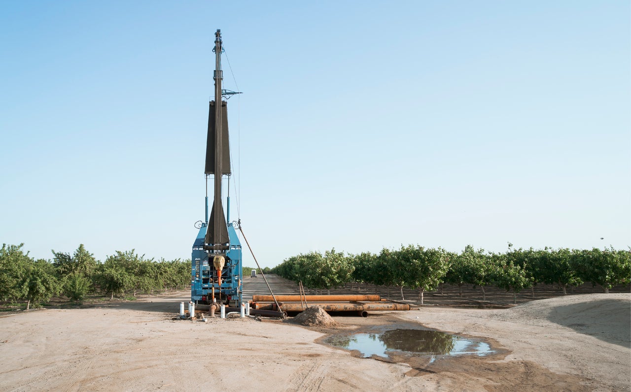Groundwater well drilling equipment in a field