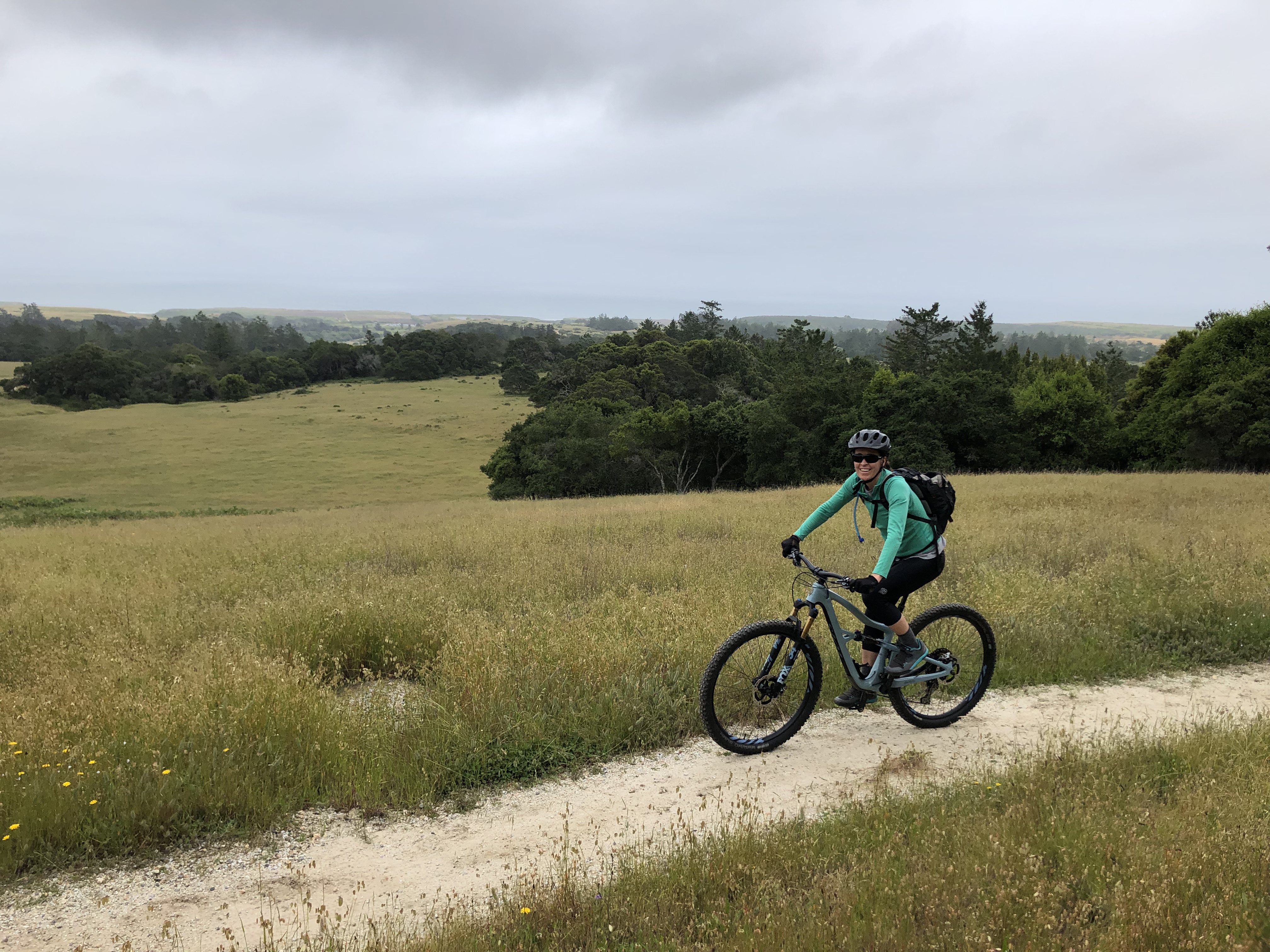 Woman riding bicycle on dirt trail 