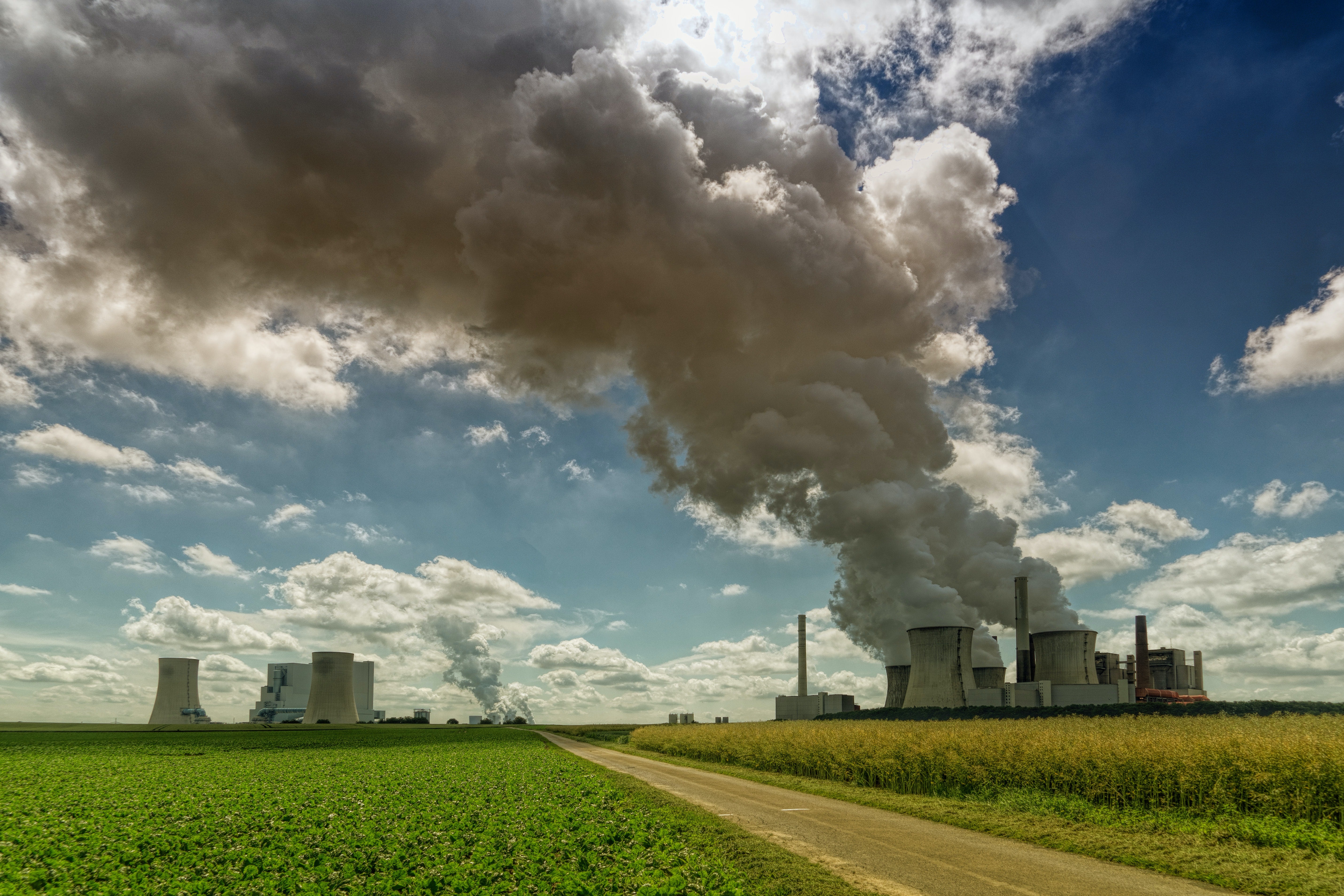 Factory in agricultural field with smoke