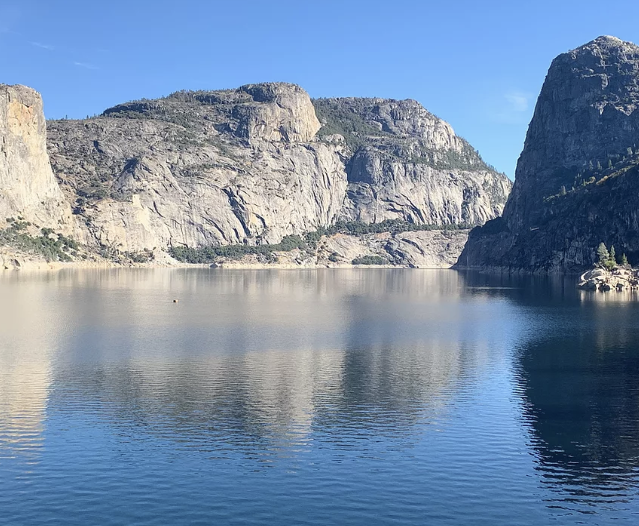 Still lake water surrounded by boulders.