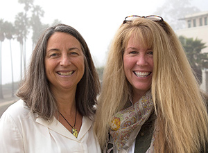 Two women stand together smiling