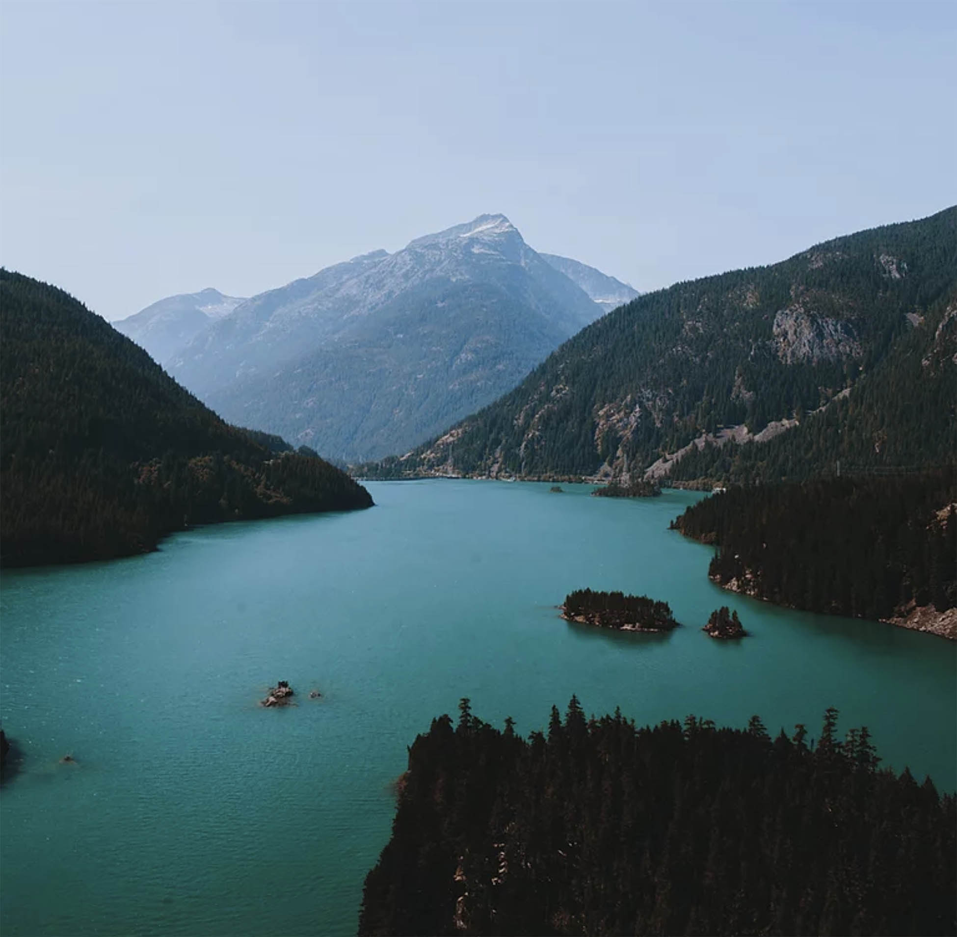 Aqua lake surrounded by forested hills