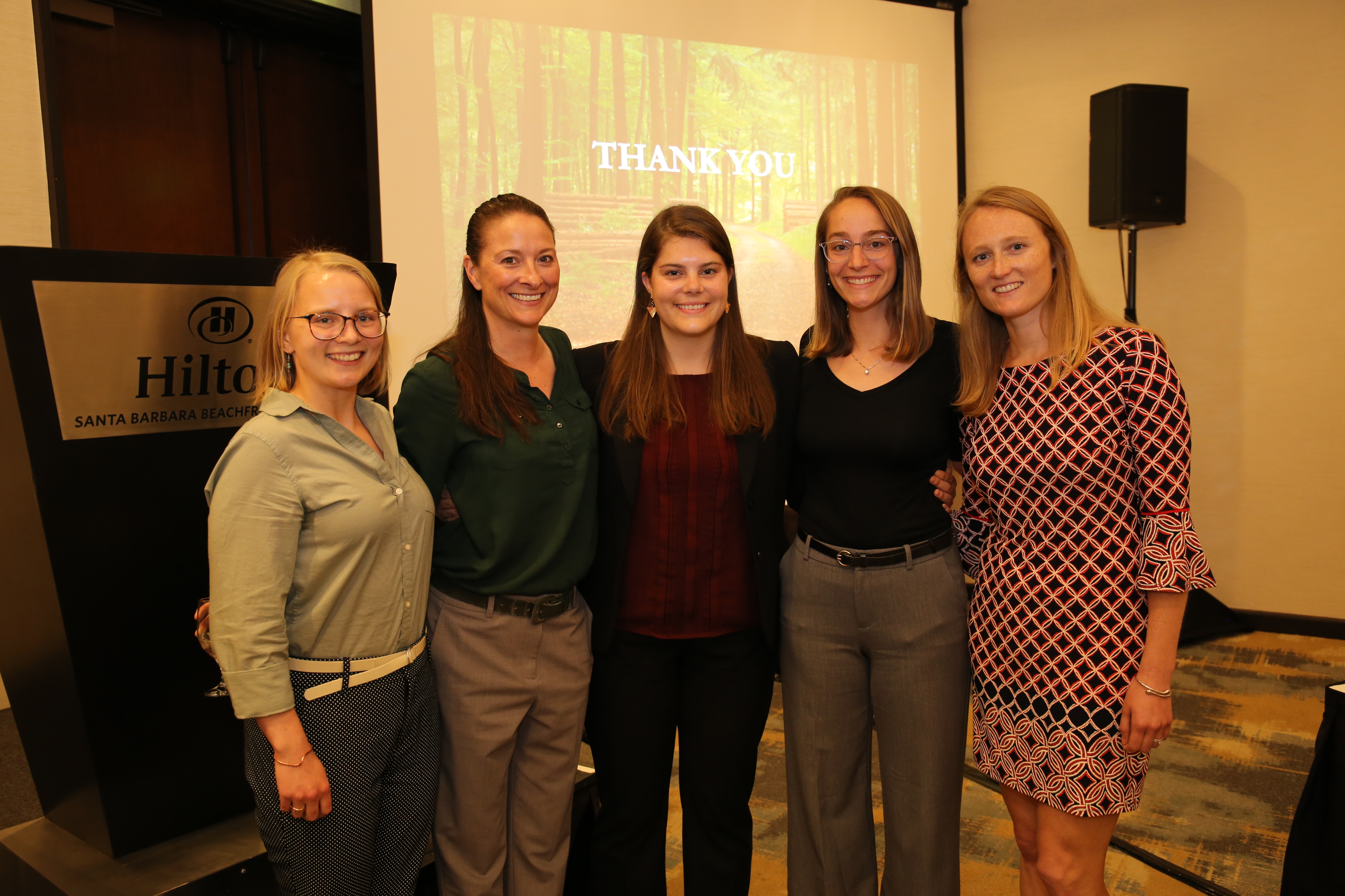 A group of five students pose after their presentation