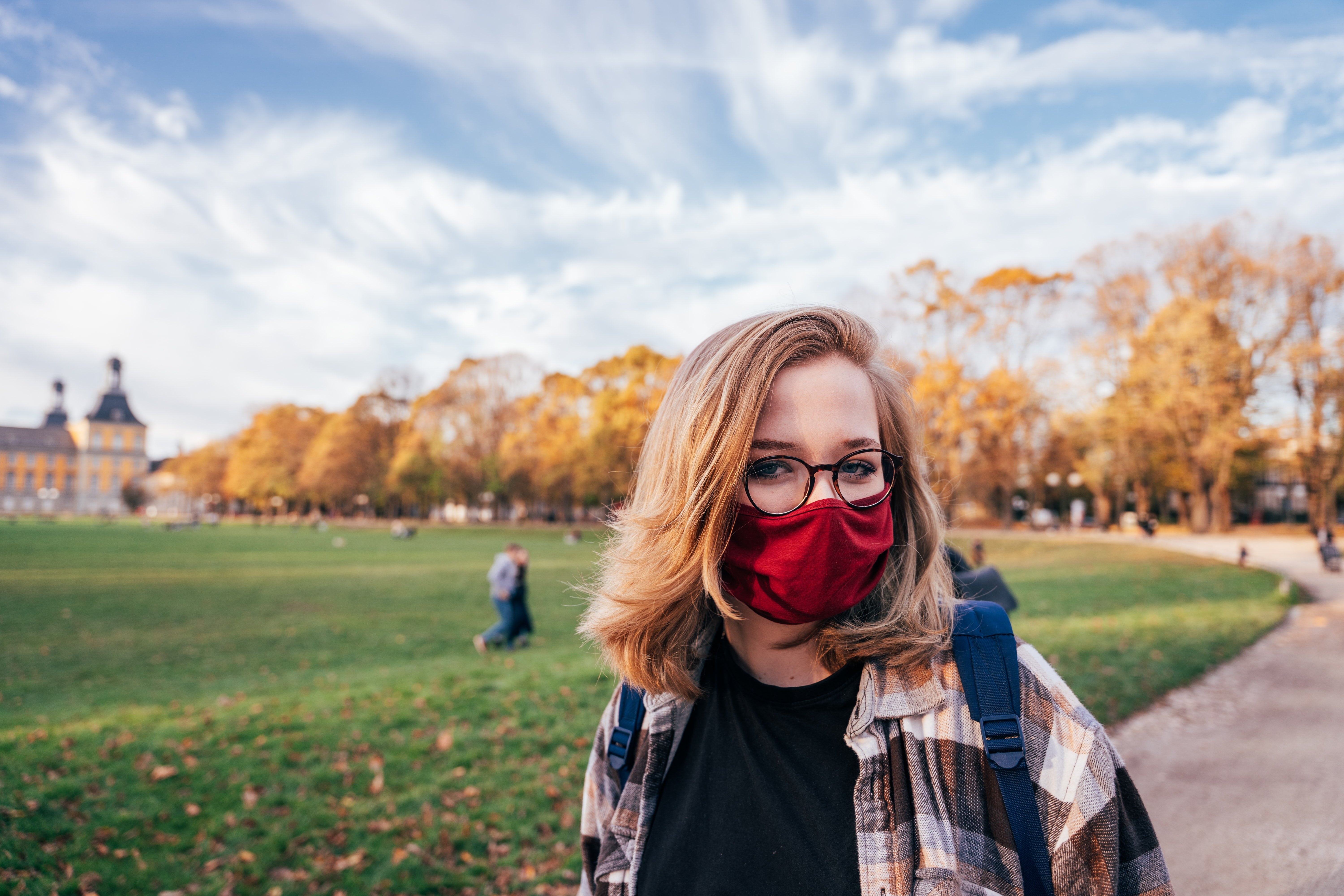 Woman on campus during fall wearing face mask