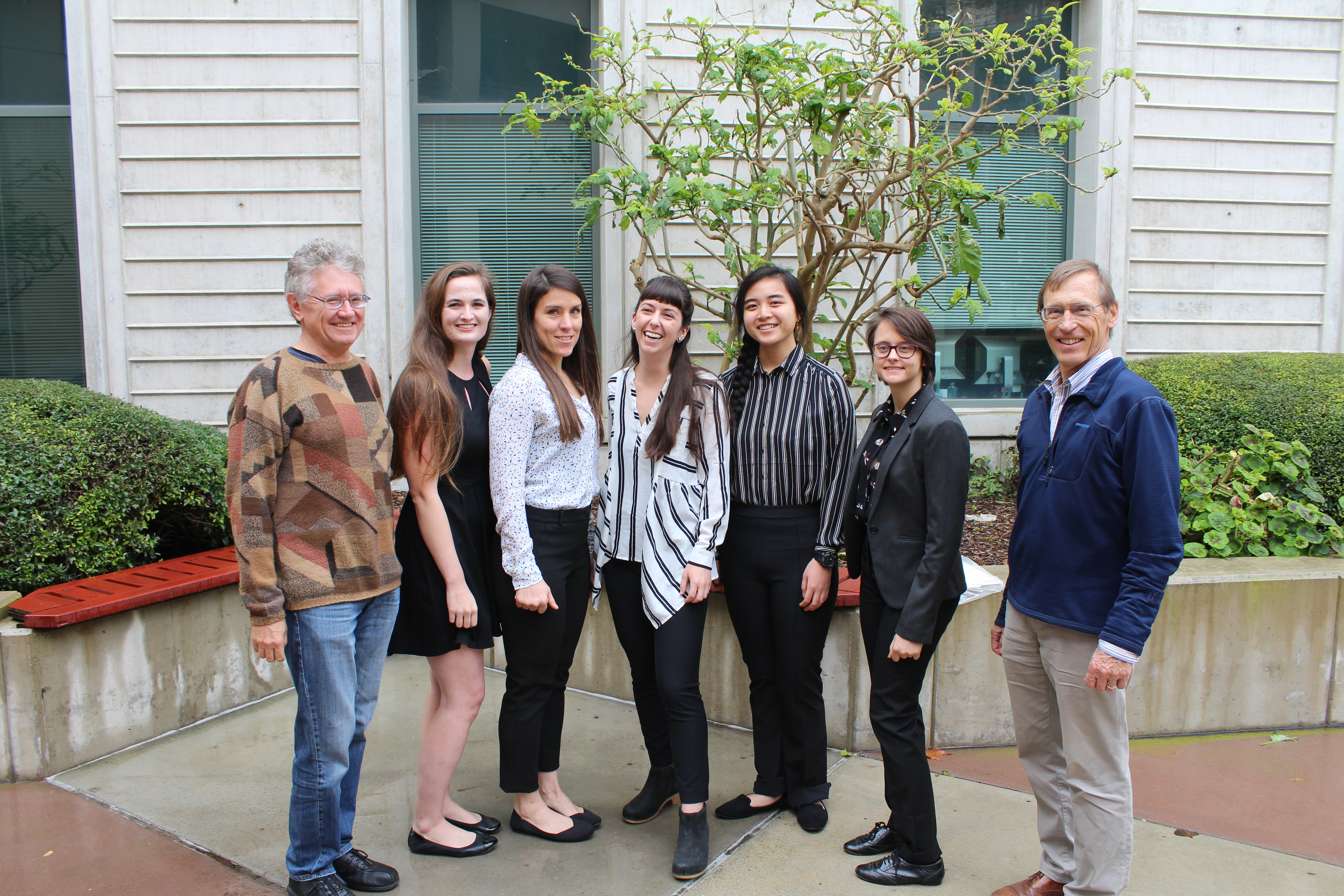 Five female students standing with two male faculty members