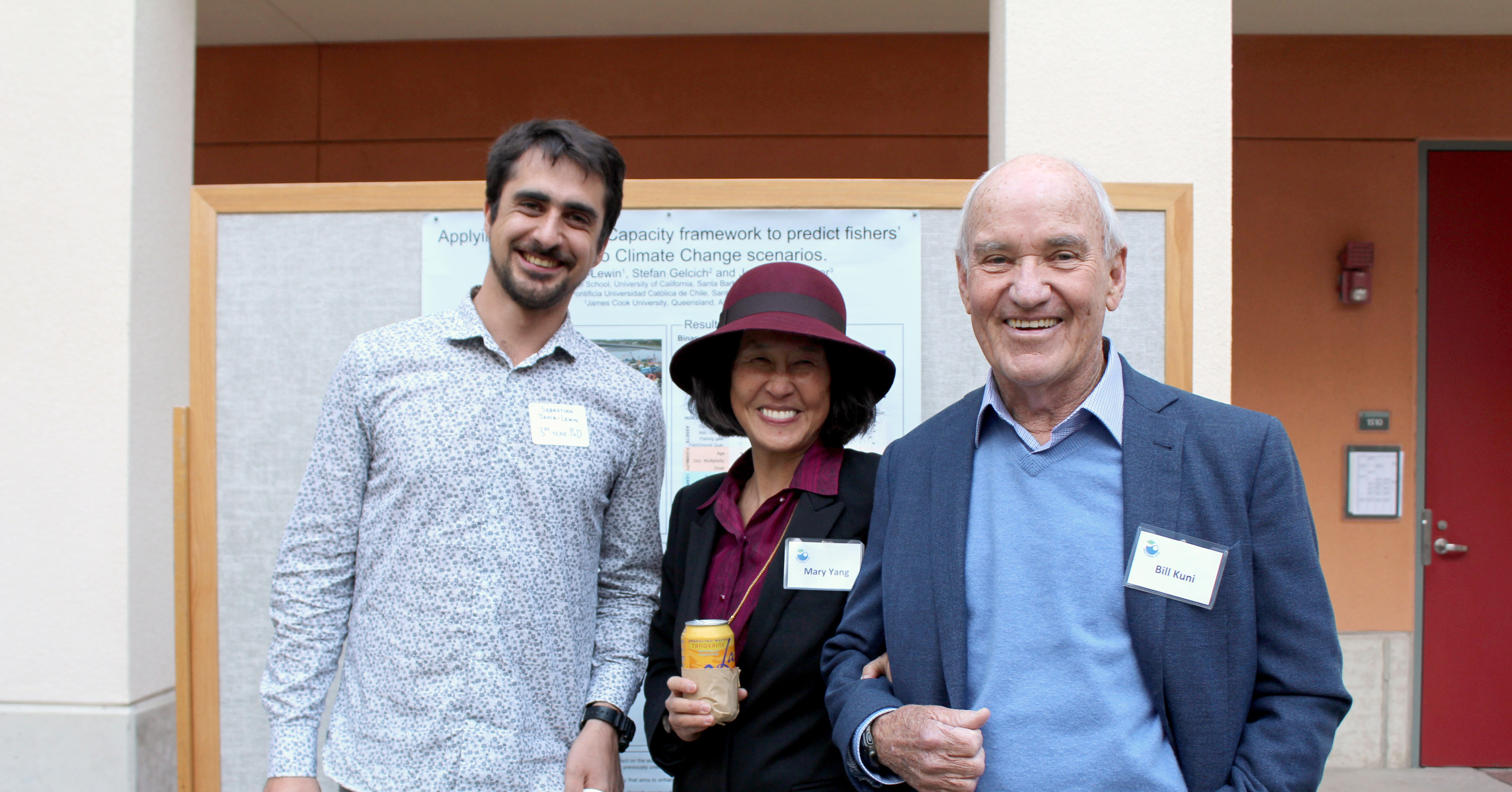 Male doctoral student stands next to an older couple