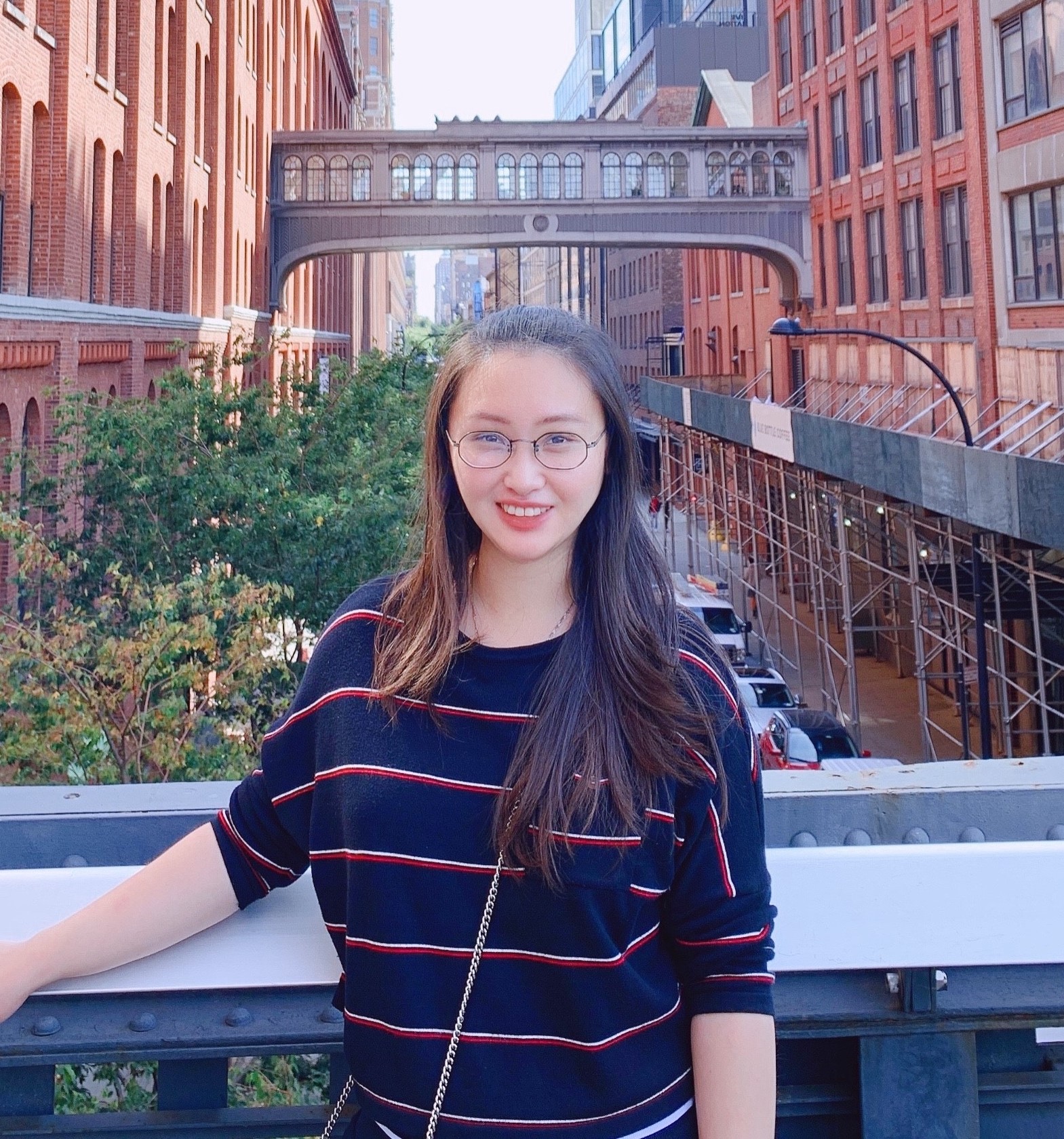 Qian Gao stands in front of a bridge