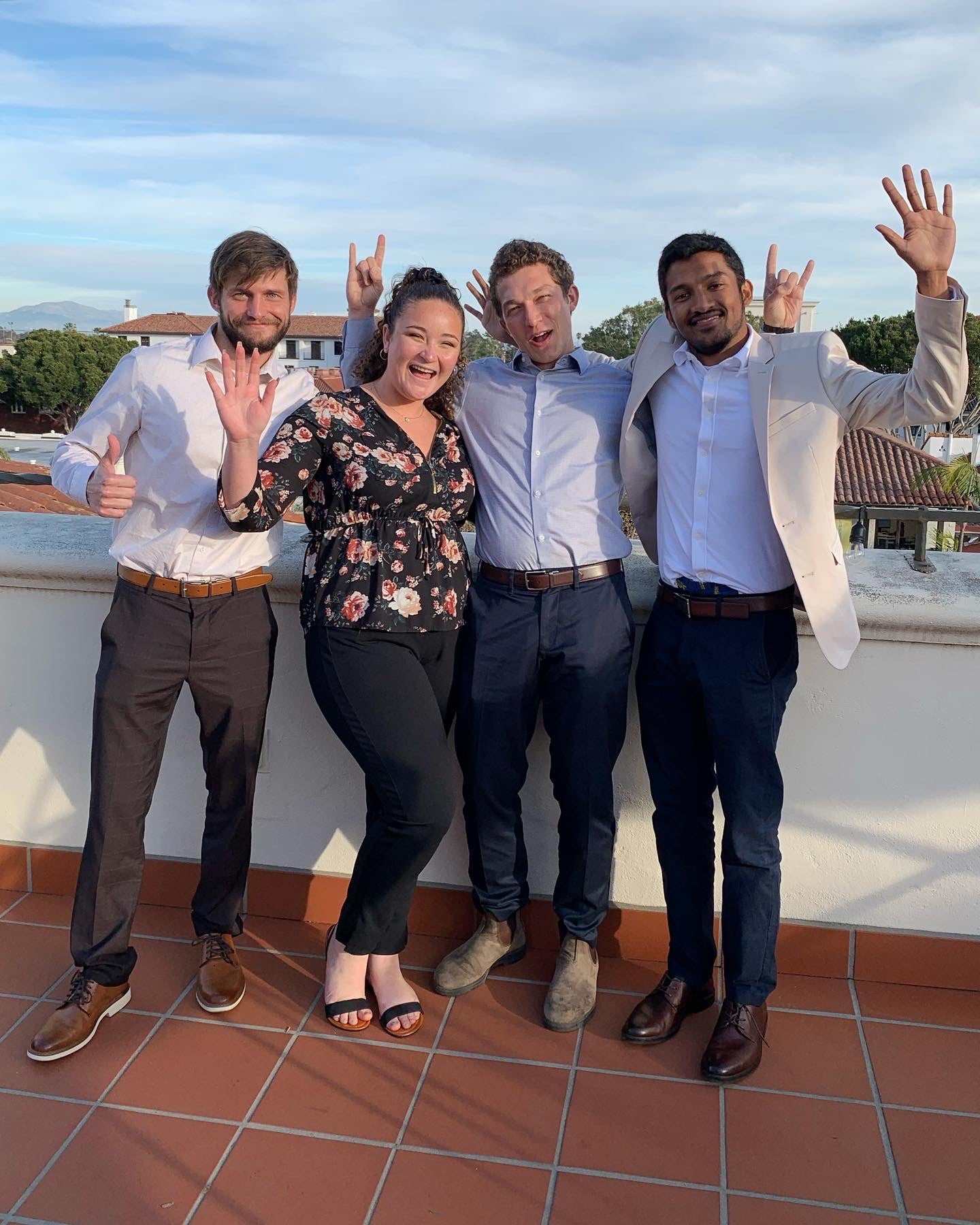 Group of four student pose together in celebration