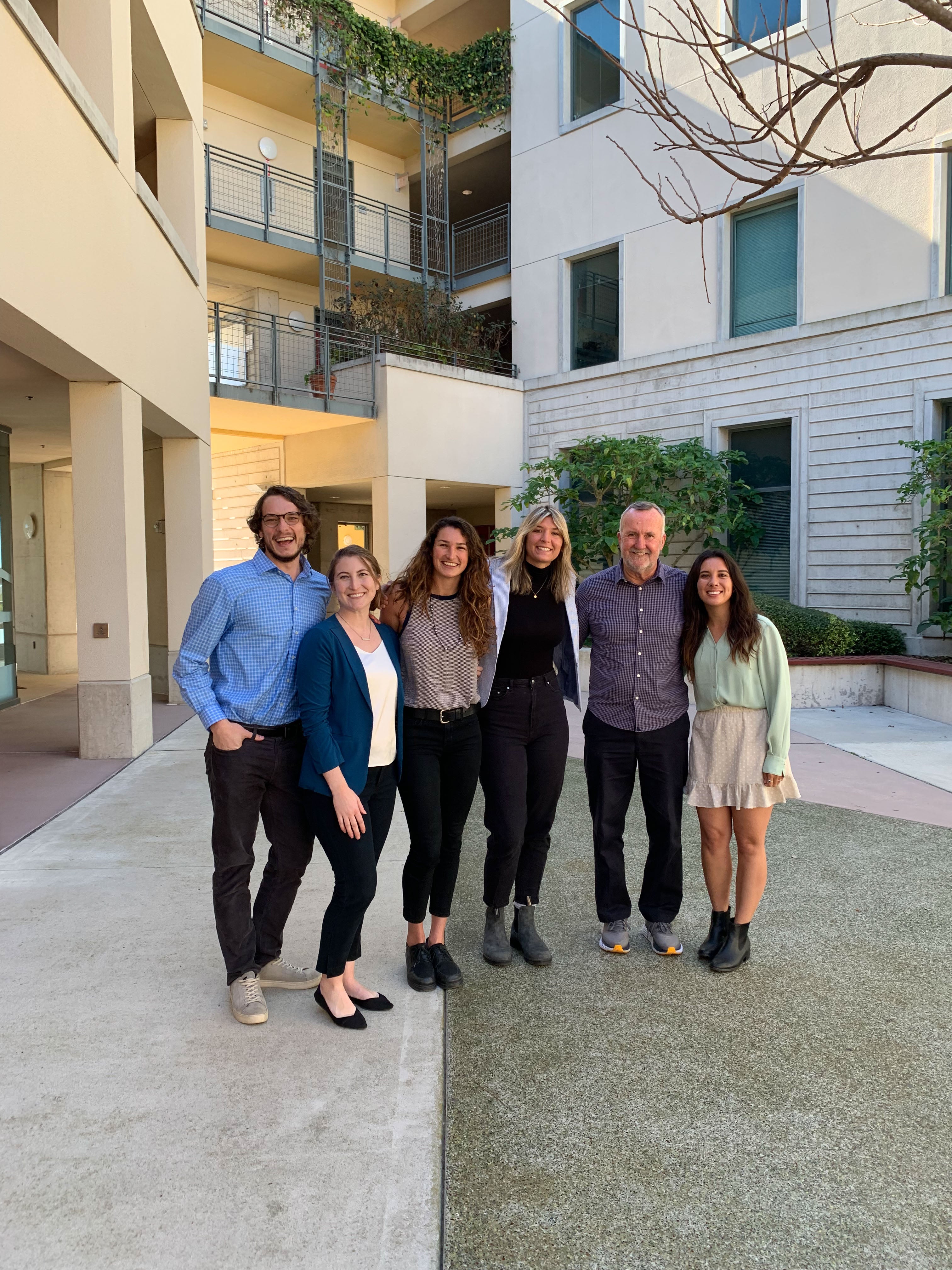 Group of five students posing together with professor