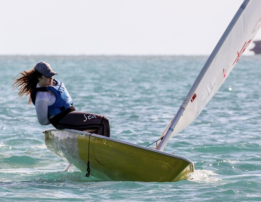 Woman maneuvering a sailboat in the ocean