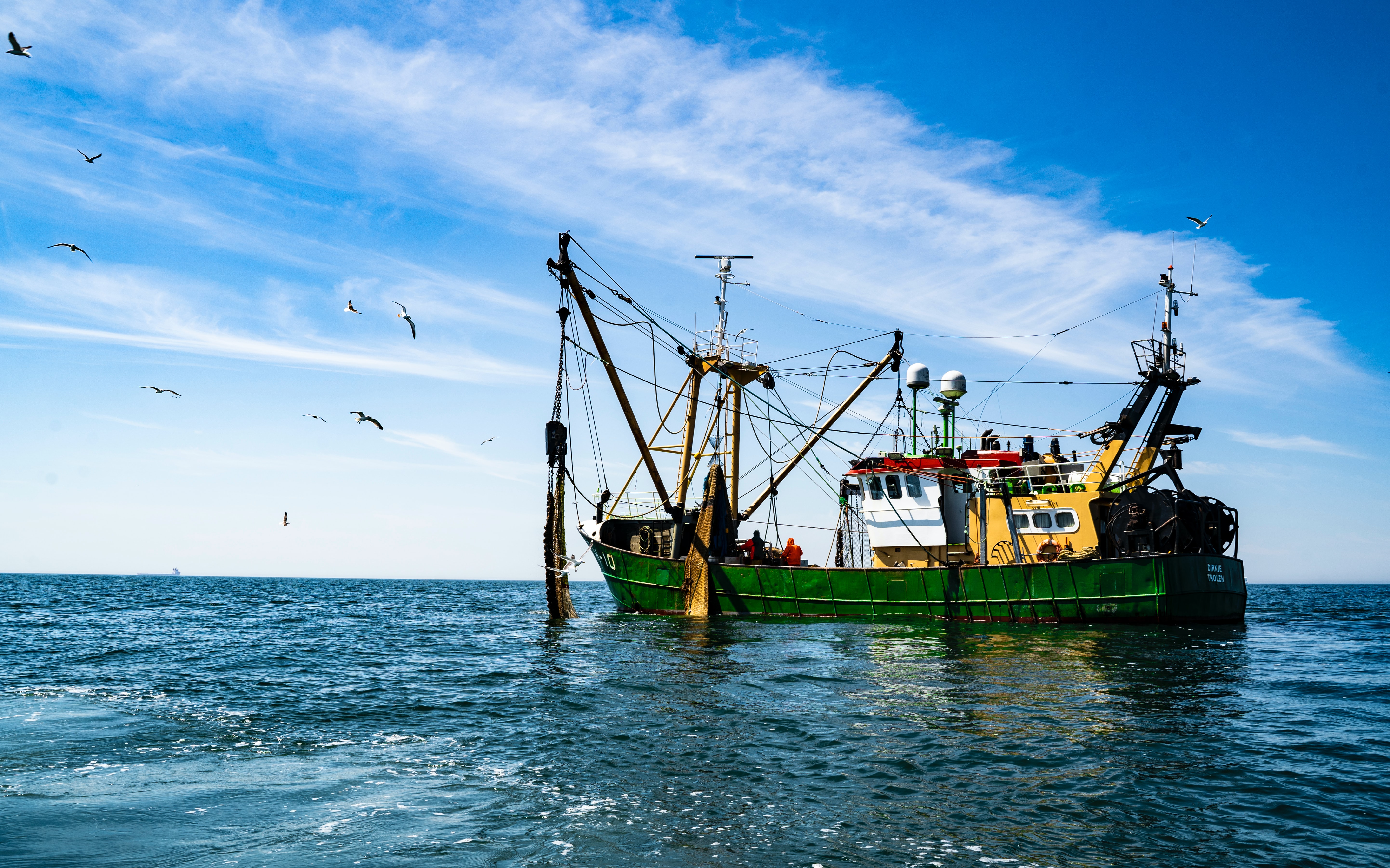 Fishing boat out in the blue ocean, with clear blue skies above