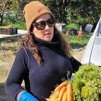 Woman carrying basket of carrots