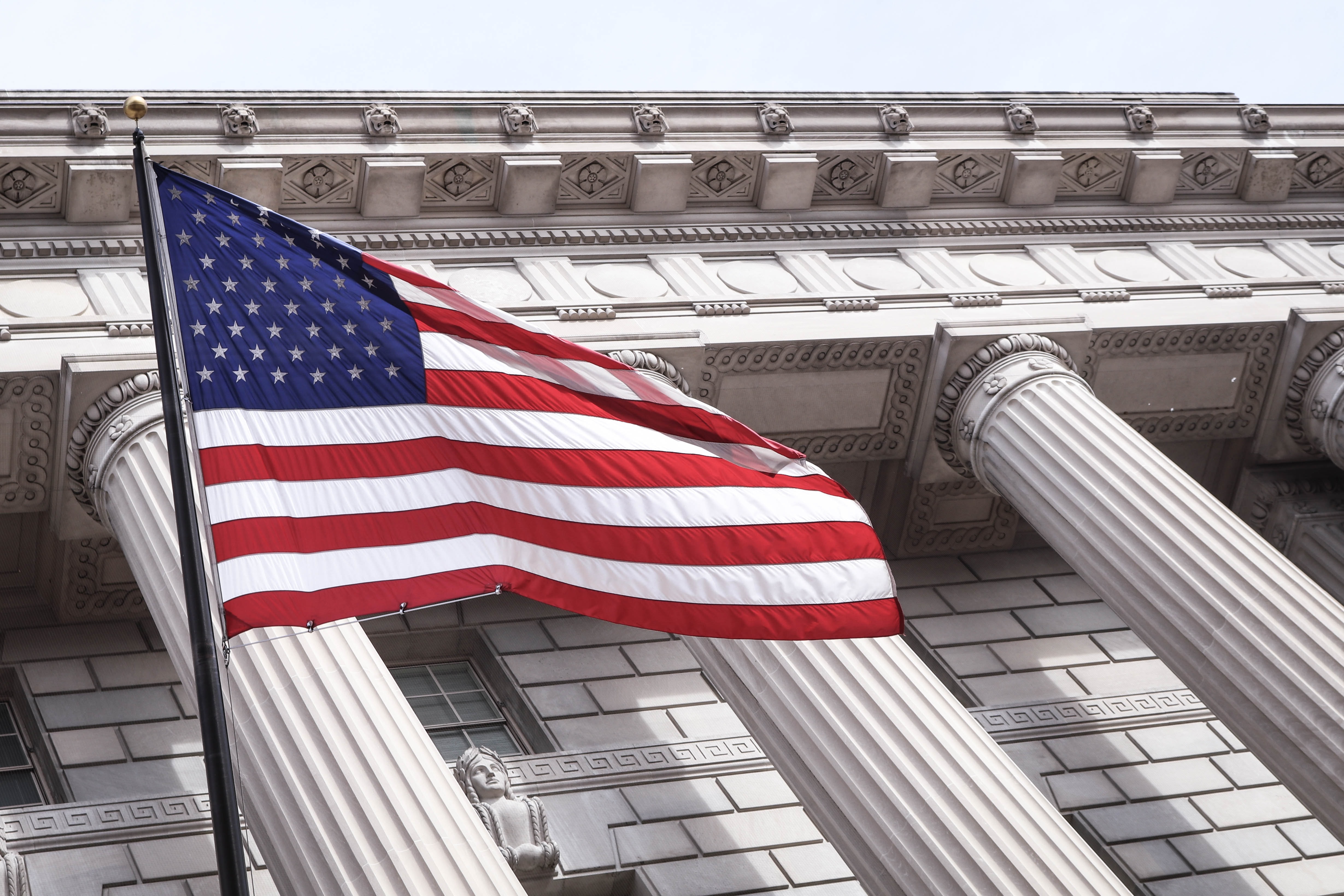 United States flag flies in front of a stately building