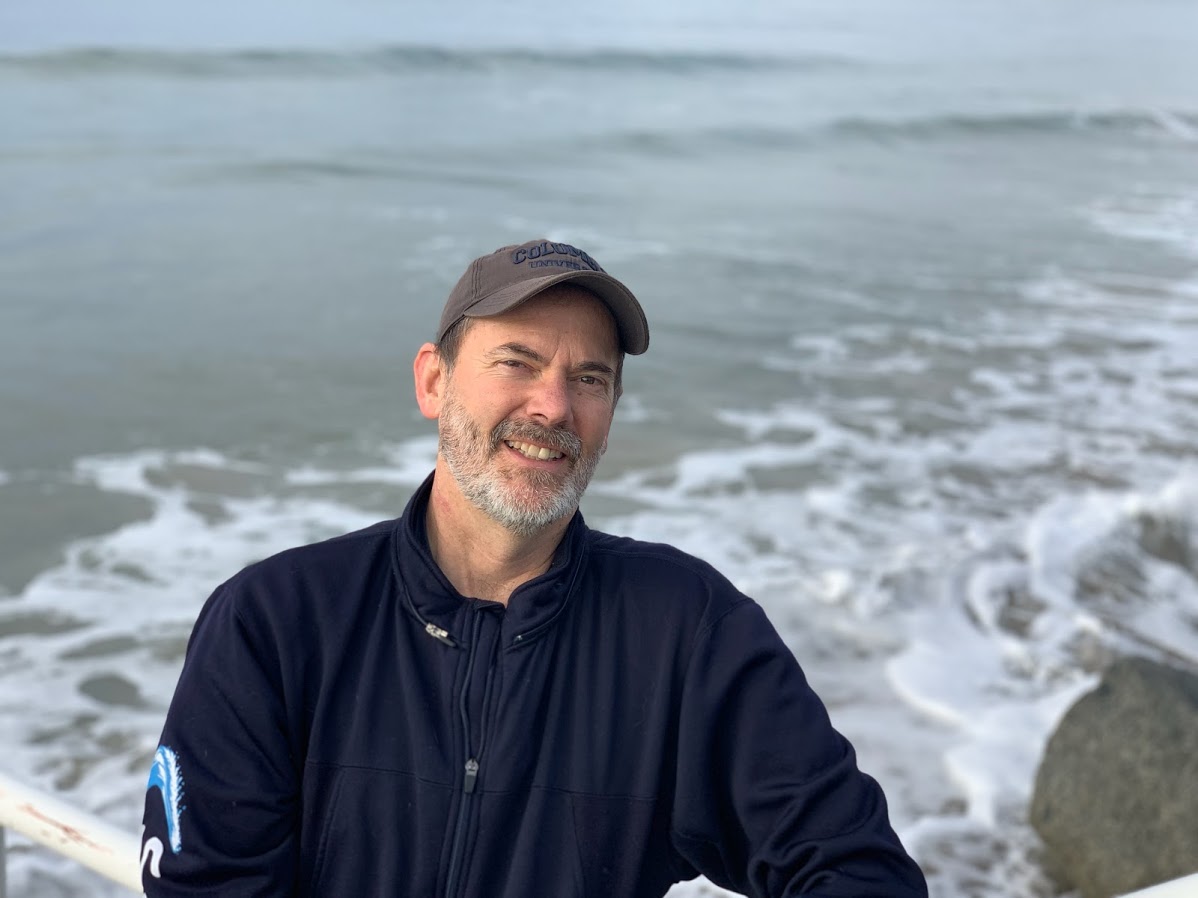 Charles Lester stands in front of the ocean