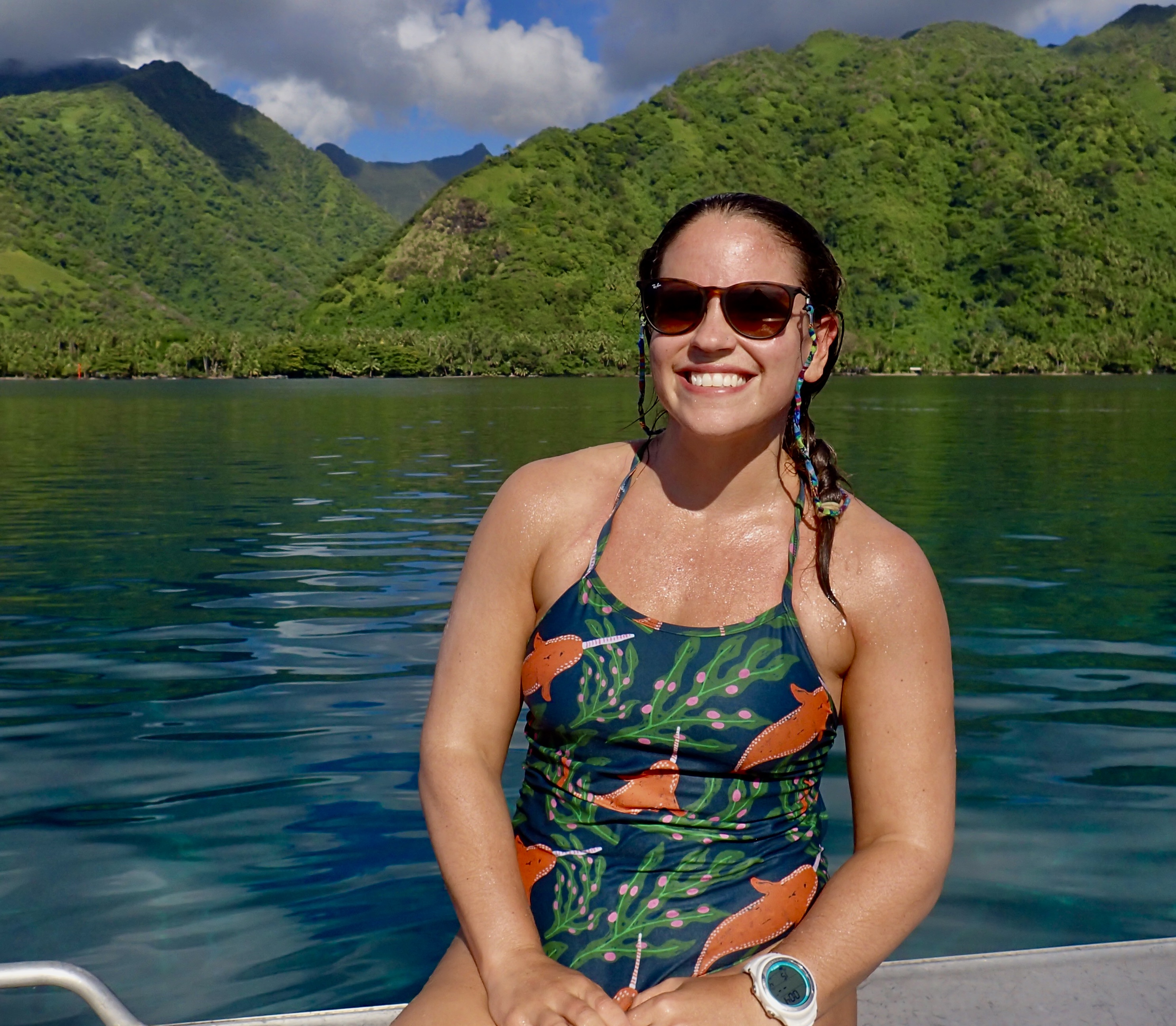 Erin Winslow sits in a boat in front of green mountains