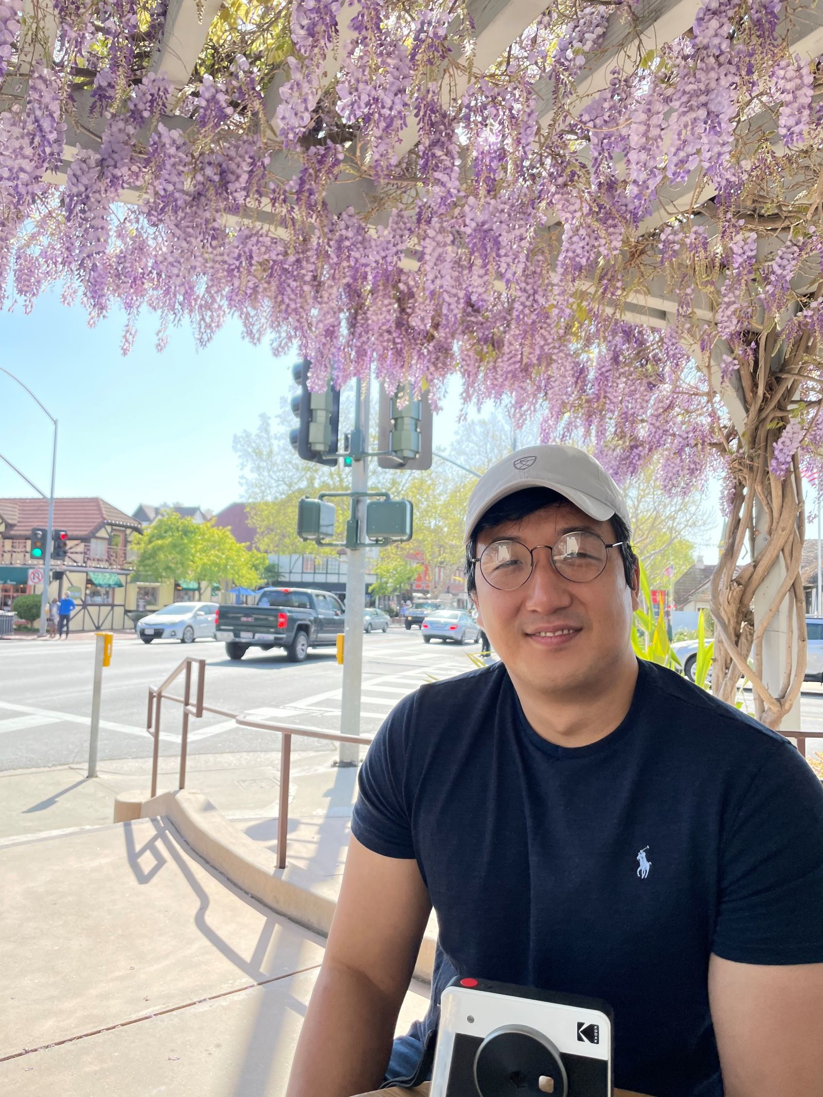 Seonghoon Kim sits under purple flowers