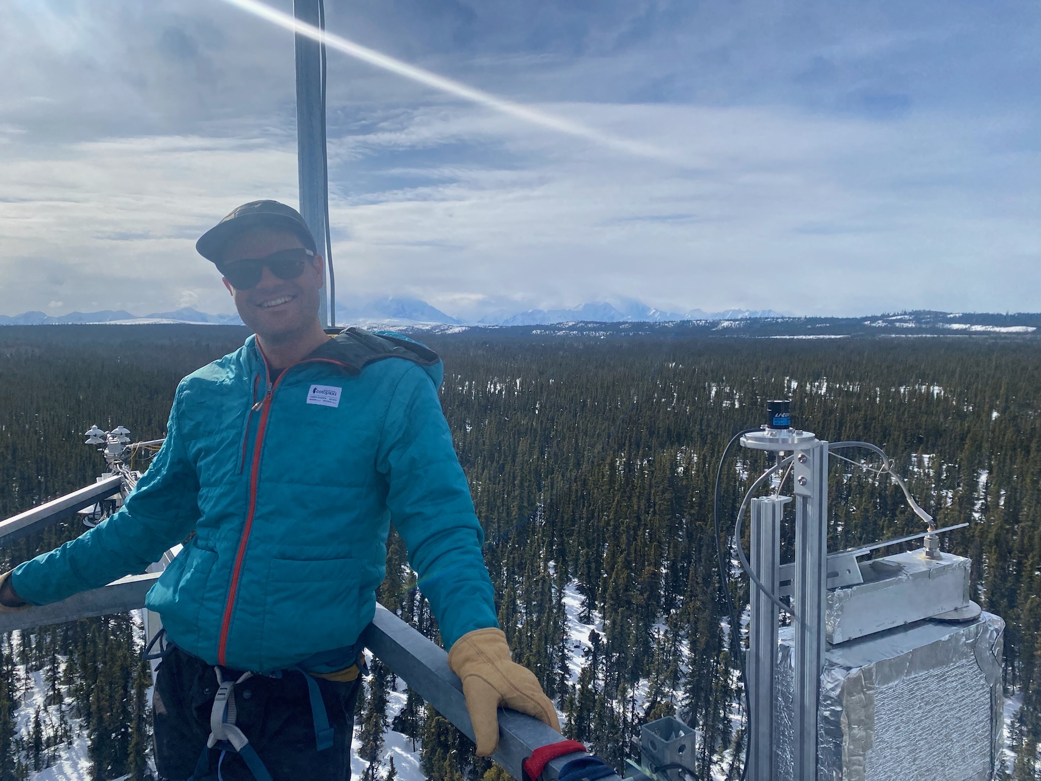 Troy Magney stands on a platform in the snow