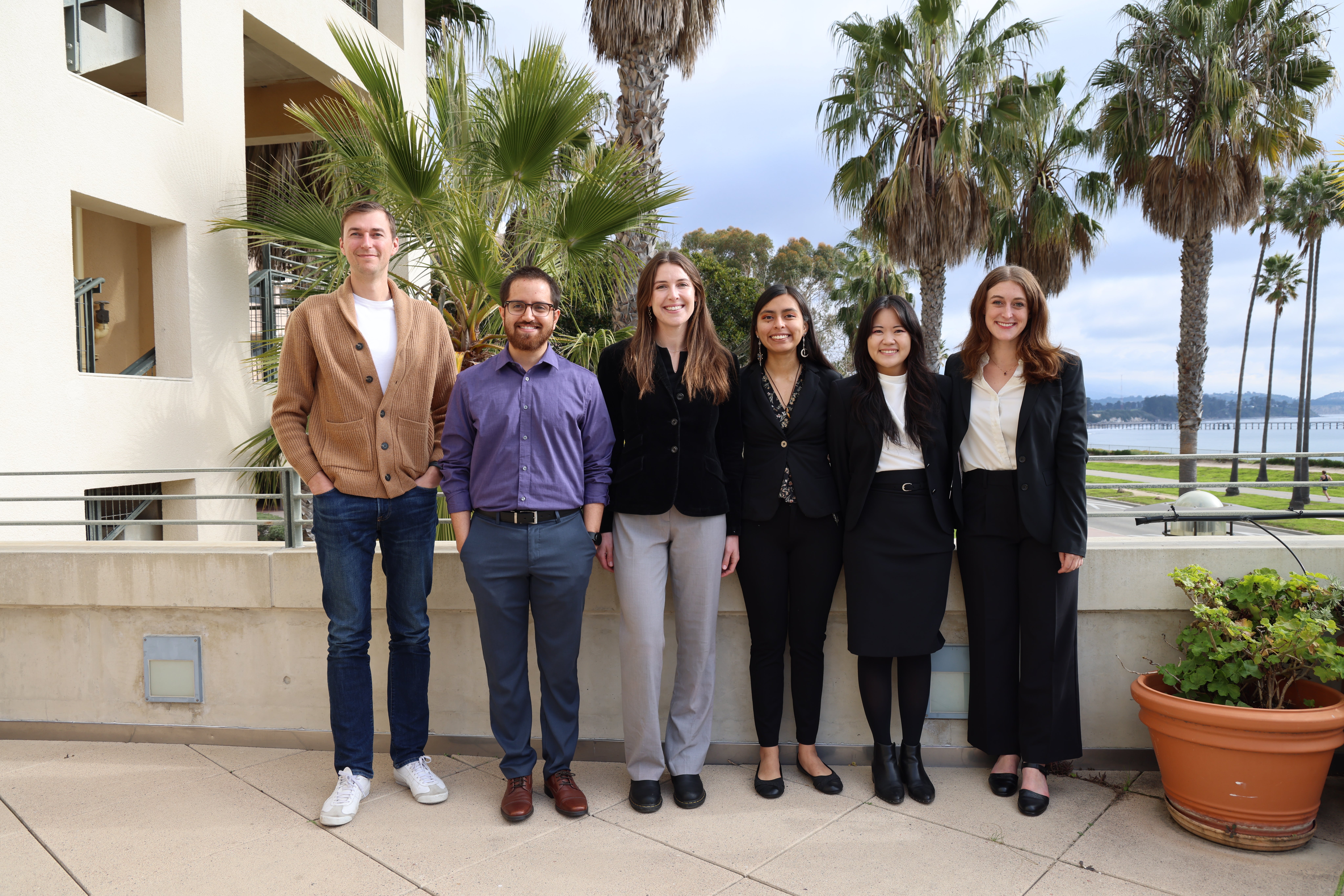 A group of masters students poses with their advisor