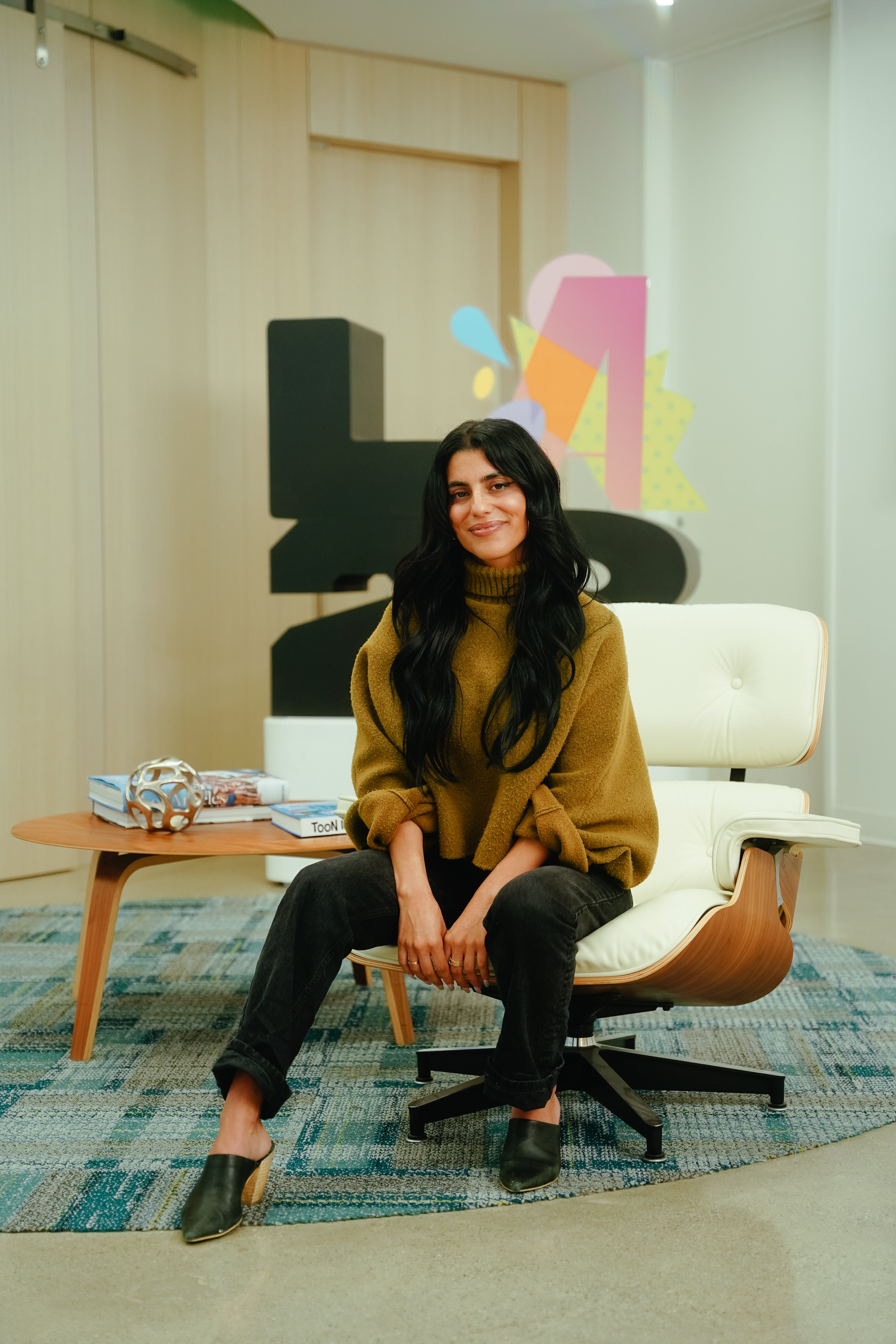 Sunny Sohrabian sits in front of an LA28 sign