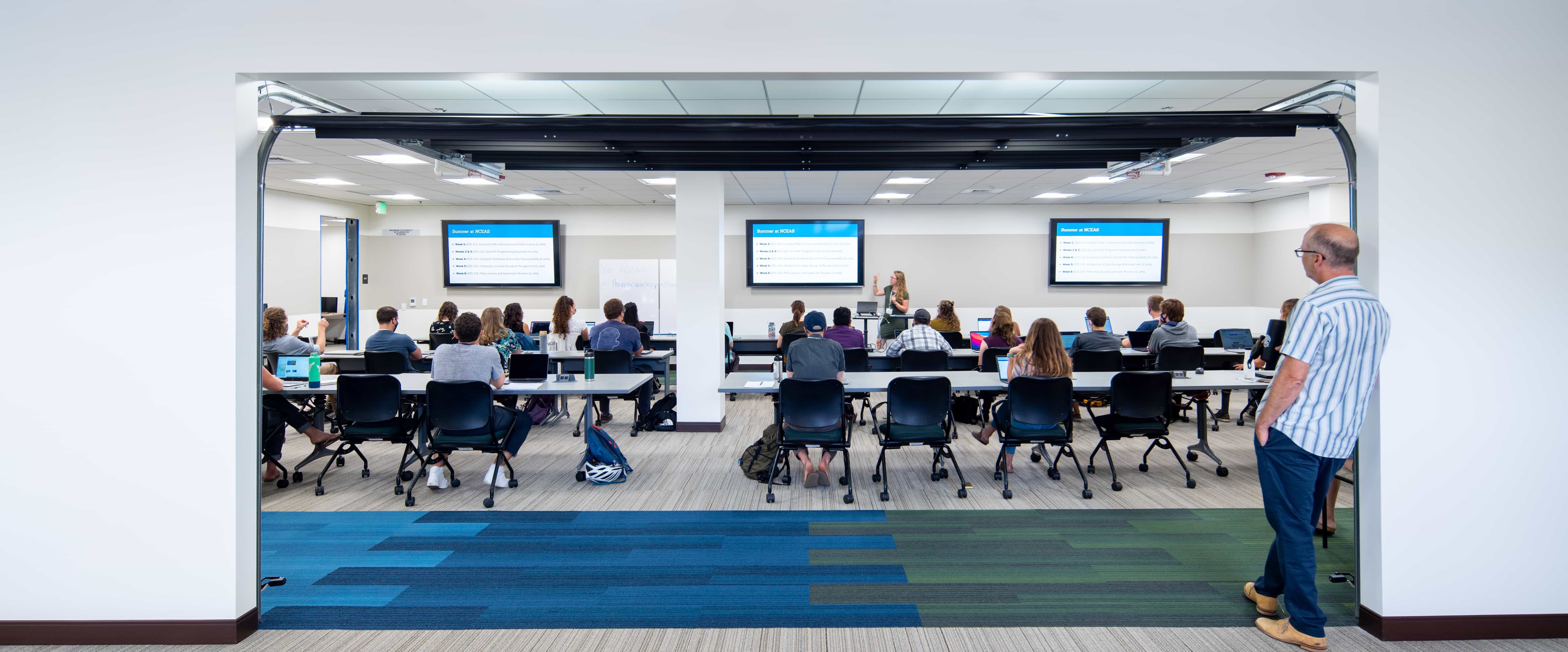 students in a classroom looking at a professor