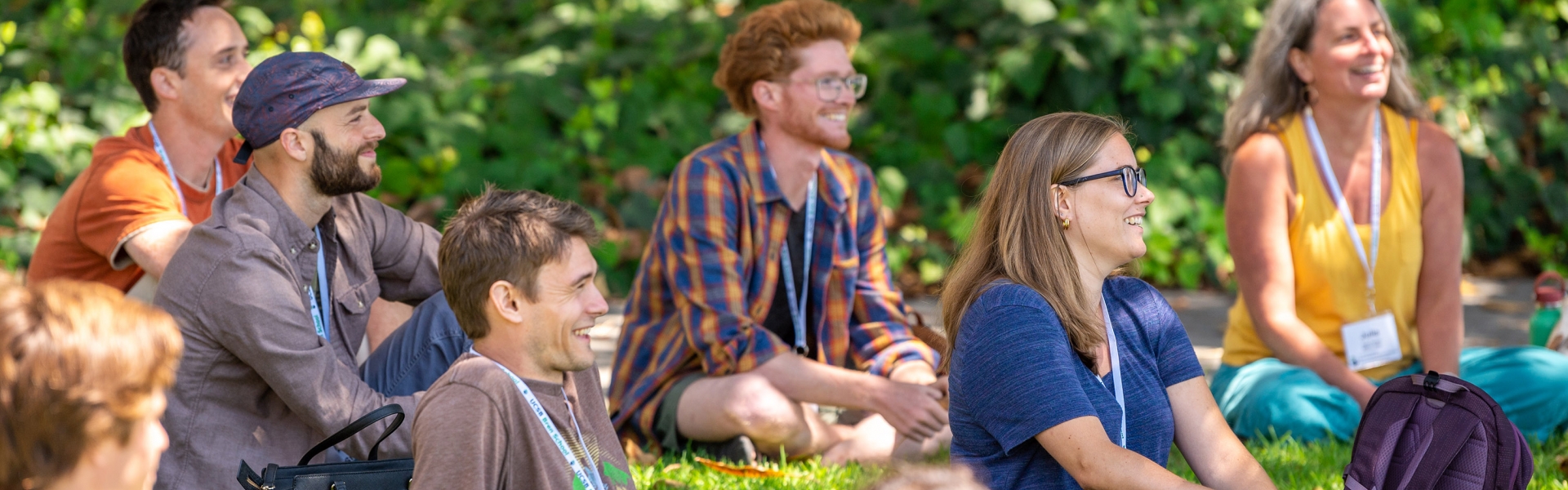 group of people sitting on a lawn