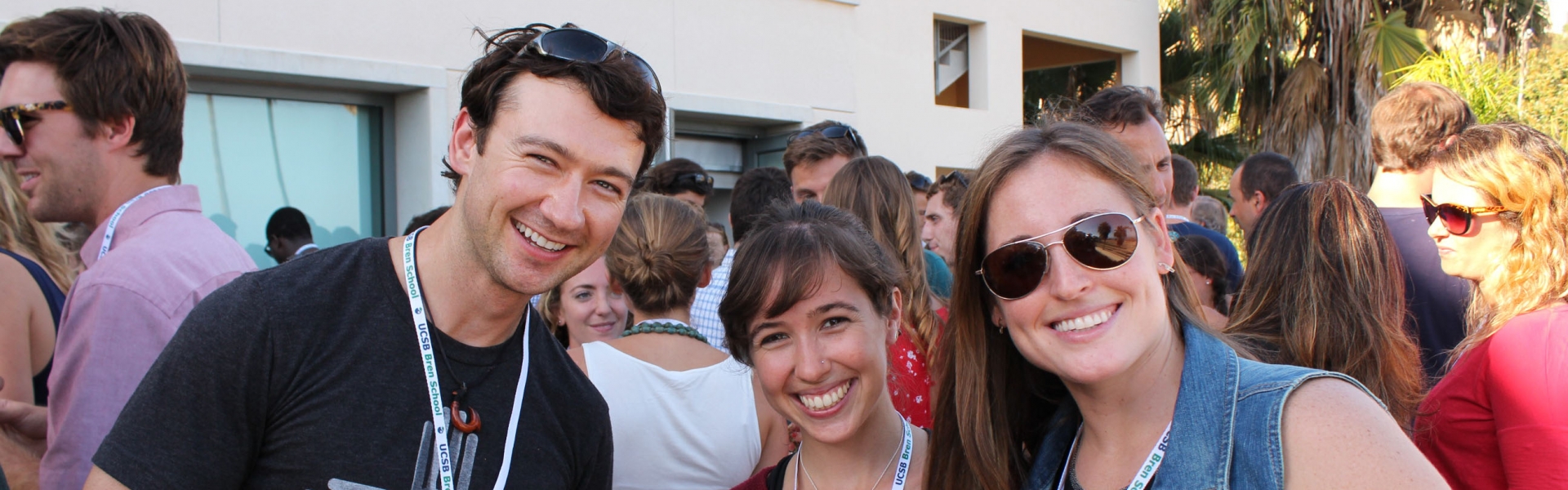 Three smiling people at an outdoor event