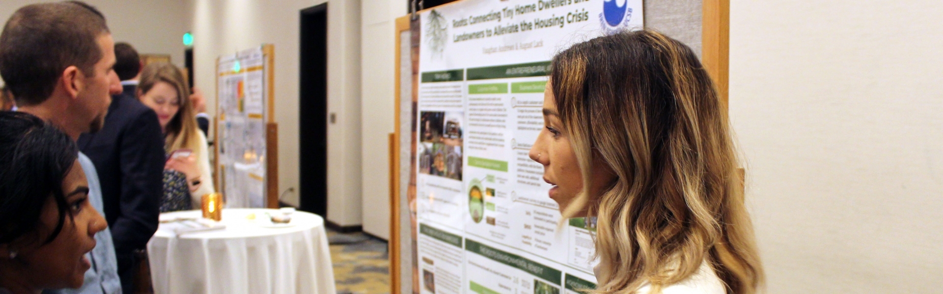 Woman standing by poster discussing with another woman