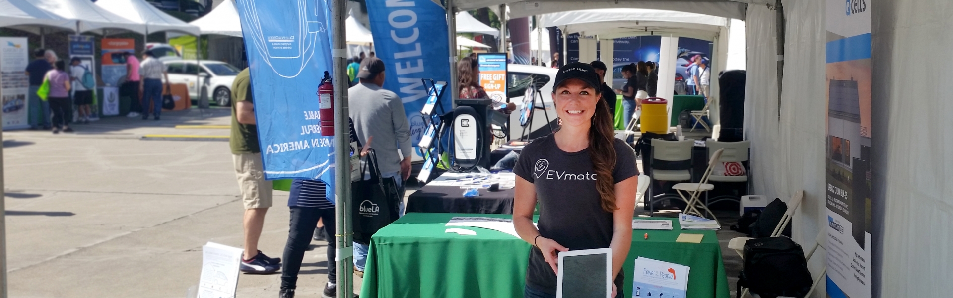 Woman holds tablet at booth at a community event