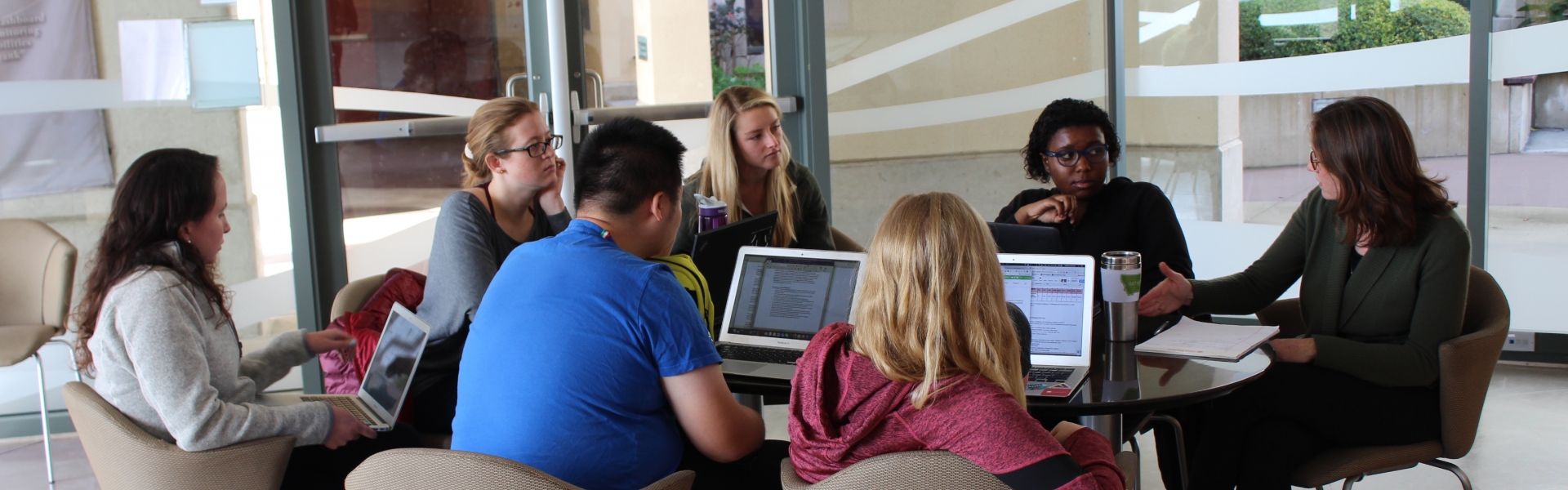 Group of students sitting with professor in discussion