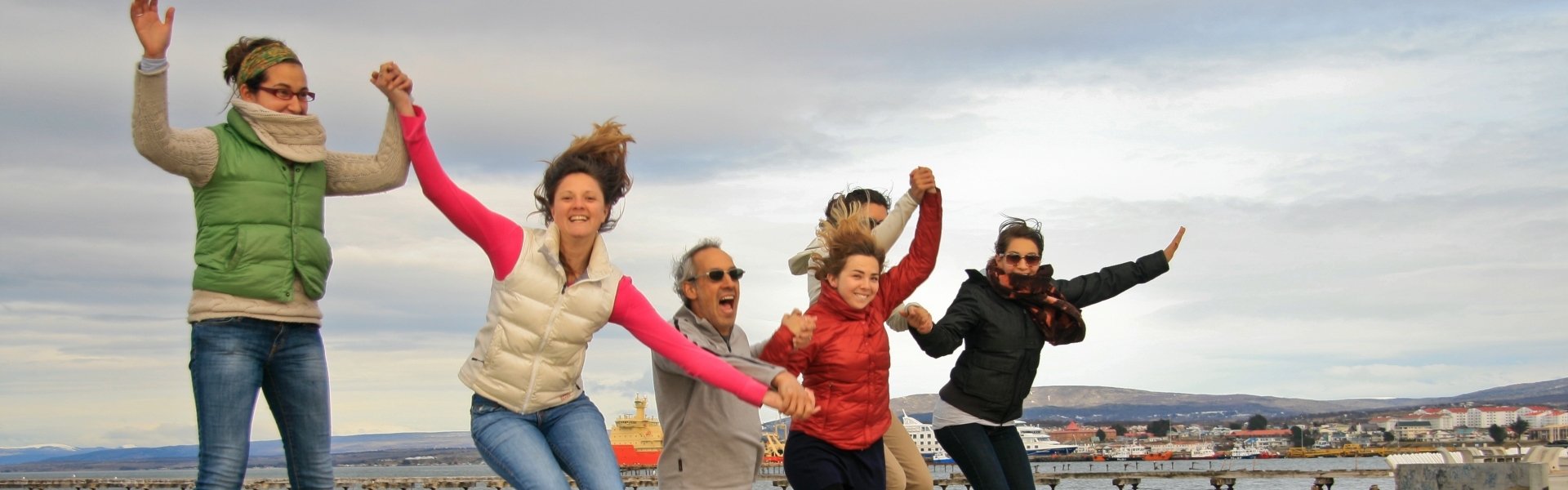 Group holding hands and jumping