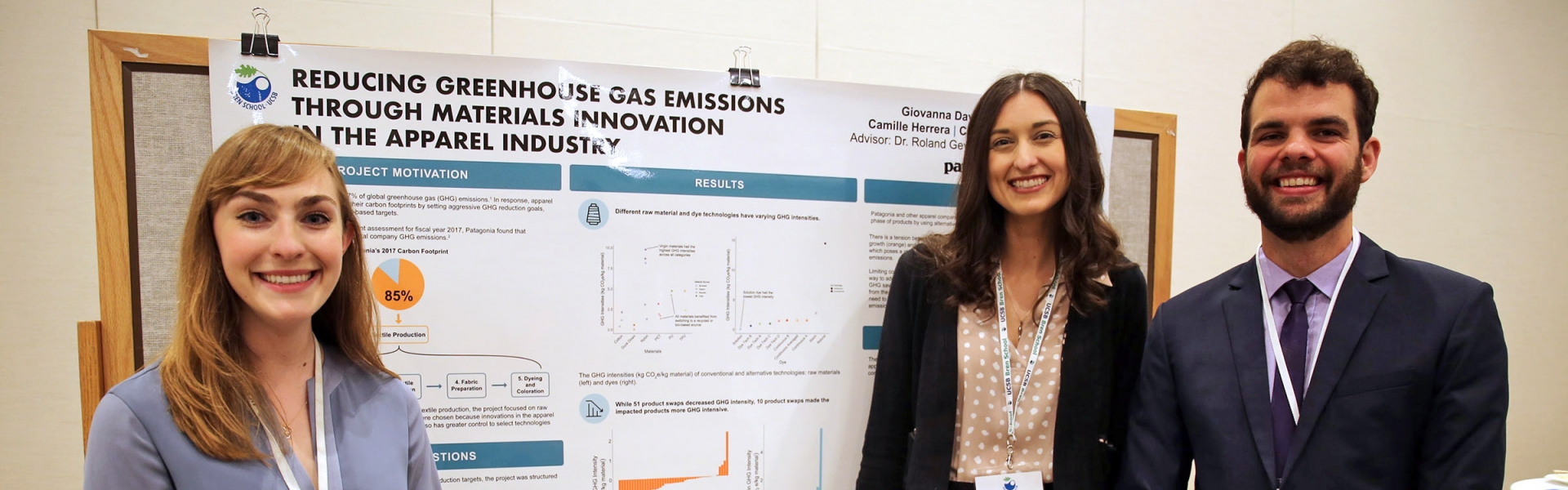 Three students stand by their research poster