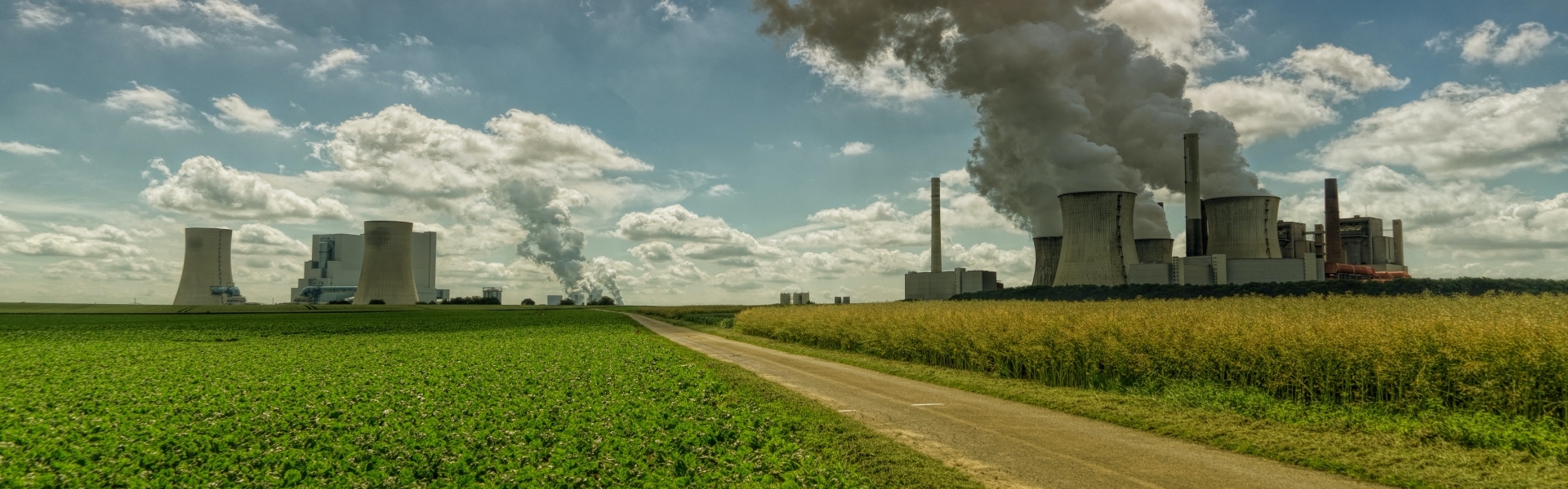 Factory in agricultural field with smoke