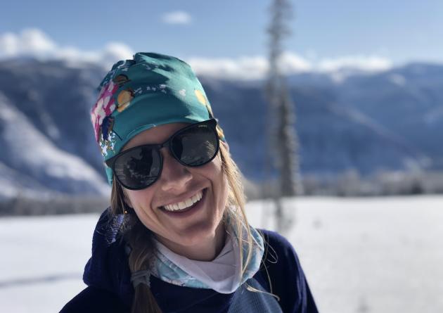 Smiling woman in sunglasses in snowy terrain