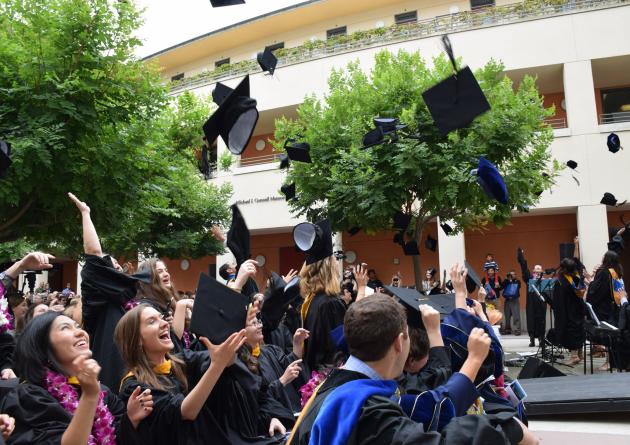 Grads throwing mortar board caps into the air