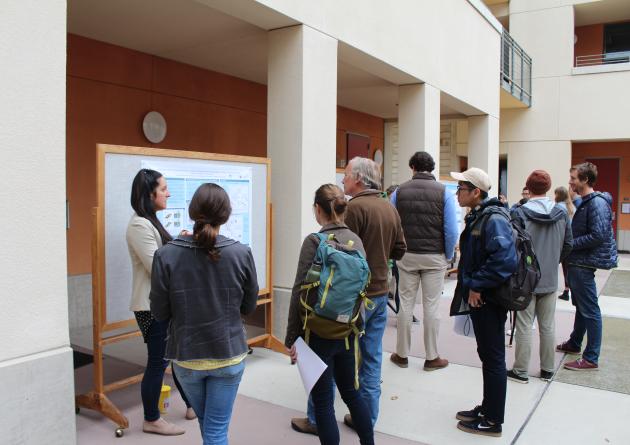 A student presents a poster in the Bren courtyard