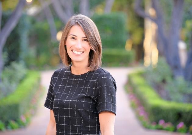 Smiling woman stands on a brick path