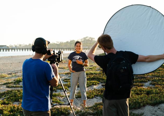 Three students shooting a video on the beach