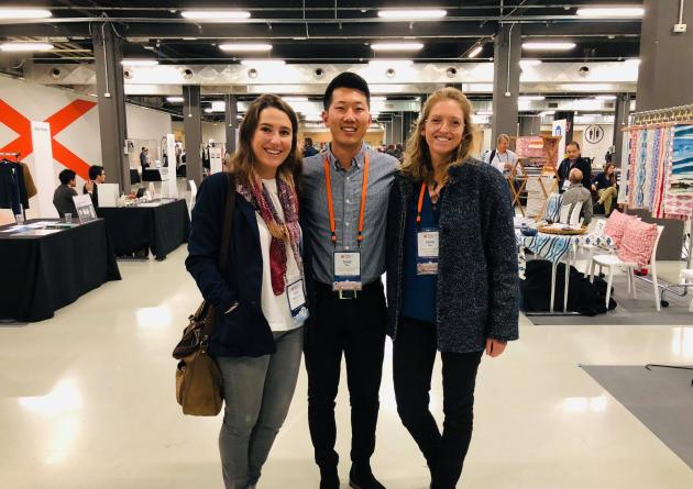 Three students pose together in a convention hall