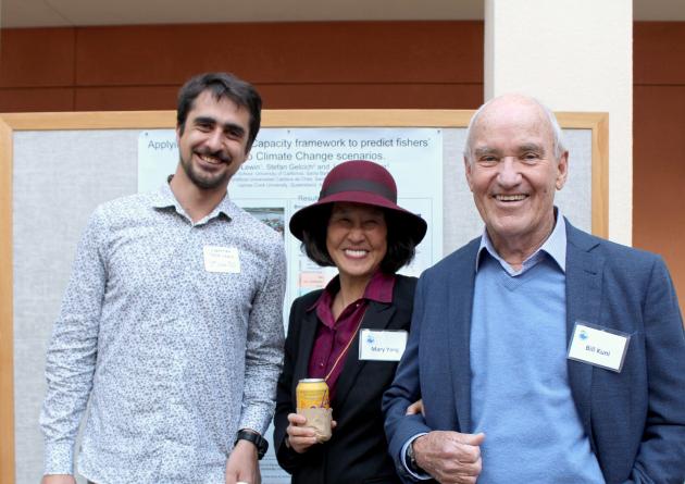 Male doctoral student stands next to an older couple