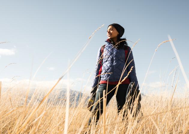 Dr. Rae Wynn-Grant standing in field of tall grass