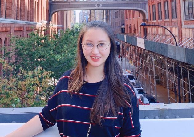 Qian Gao stands in front of a bridge