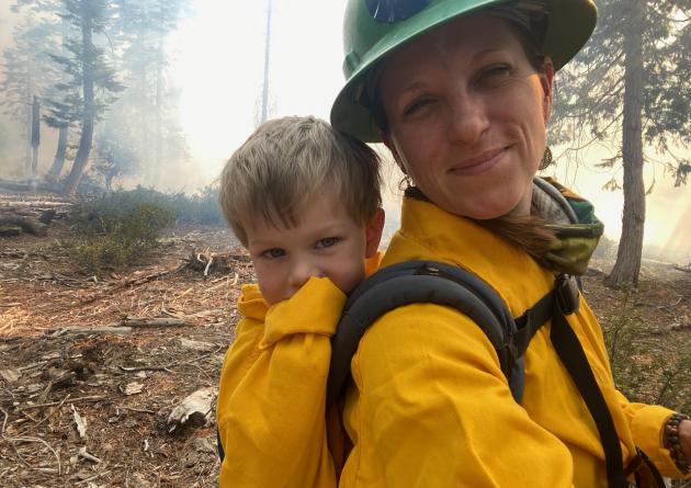 Sarah Bisbing in a forest with a child on her back