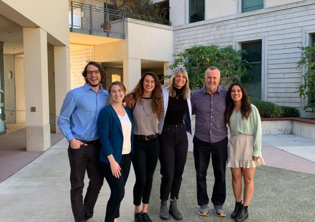 Group of five students posing together with professor