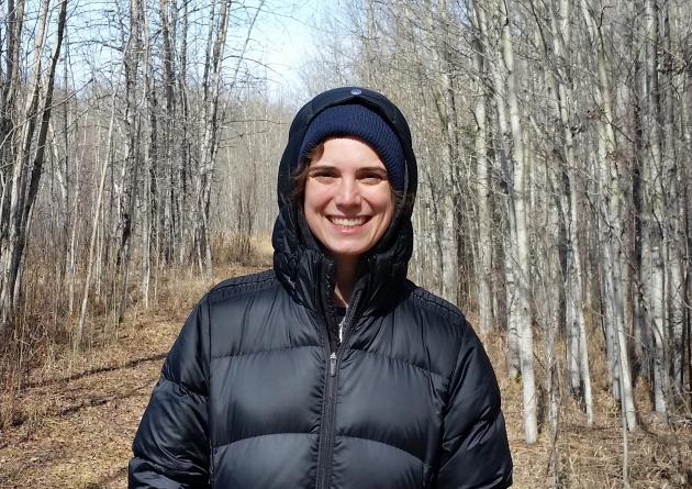 Ruth Oliver stands in the woods in a black jacket