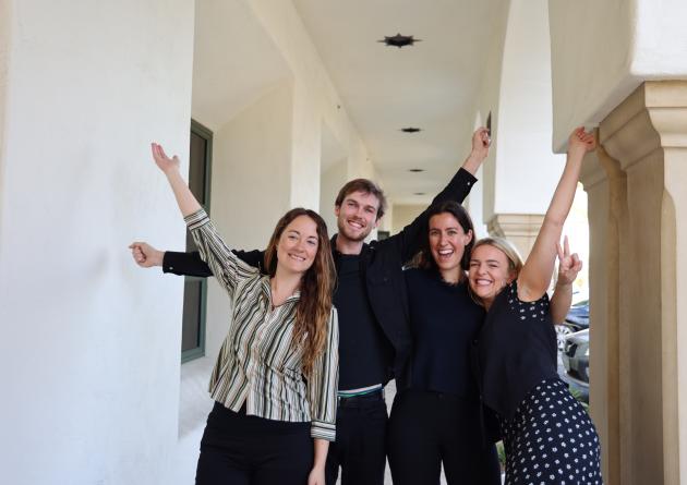 A group of masters students cheers