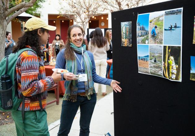 Students show a poster at the symposium