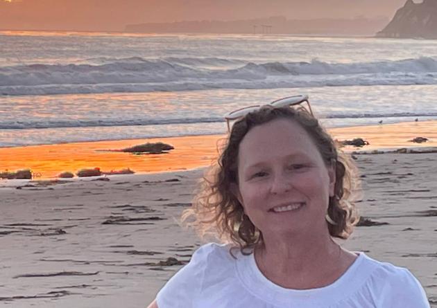 Cheryl Harrison on a beach at sunset
