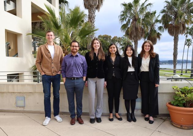 A group of masters students poses with their advisor